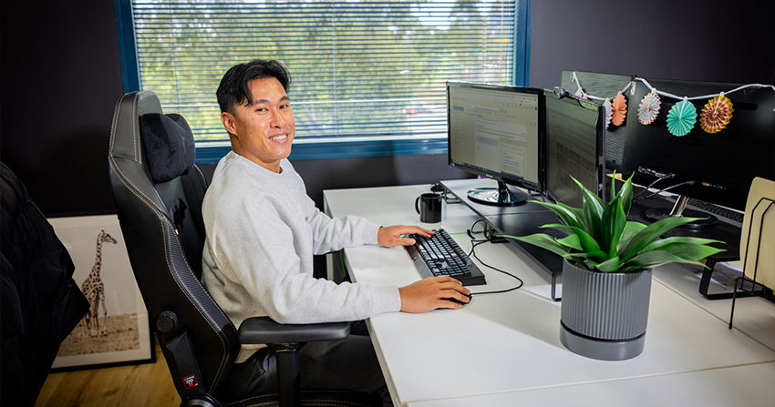 click click media team member working on digital campaigns at multi-monitor desk in a modern office